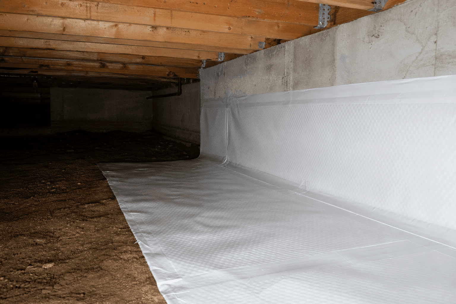 Reinforced white vapor barrier sheeting sealed across a crawl space dirt floor